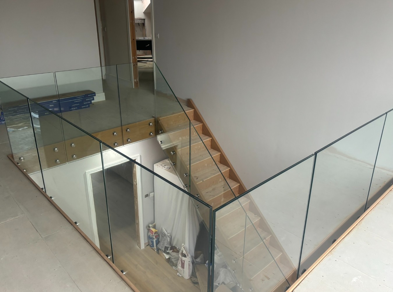 Frameless glass staircase fixed to stringer face with concealed countersunk fixings