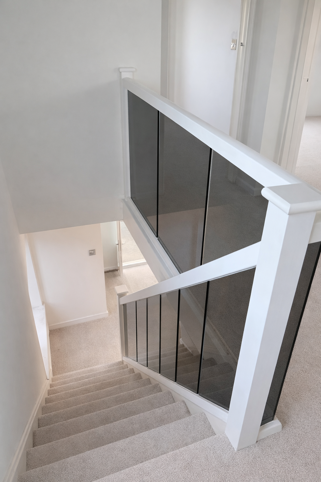White painted timber staircase renovation with glass balustrade panels