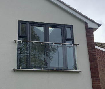 Framed stainless steel Juliet balcony with glass panel infill