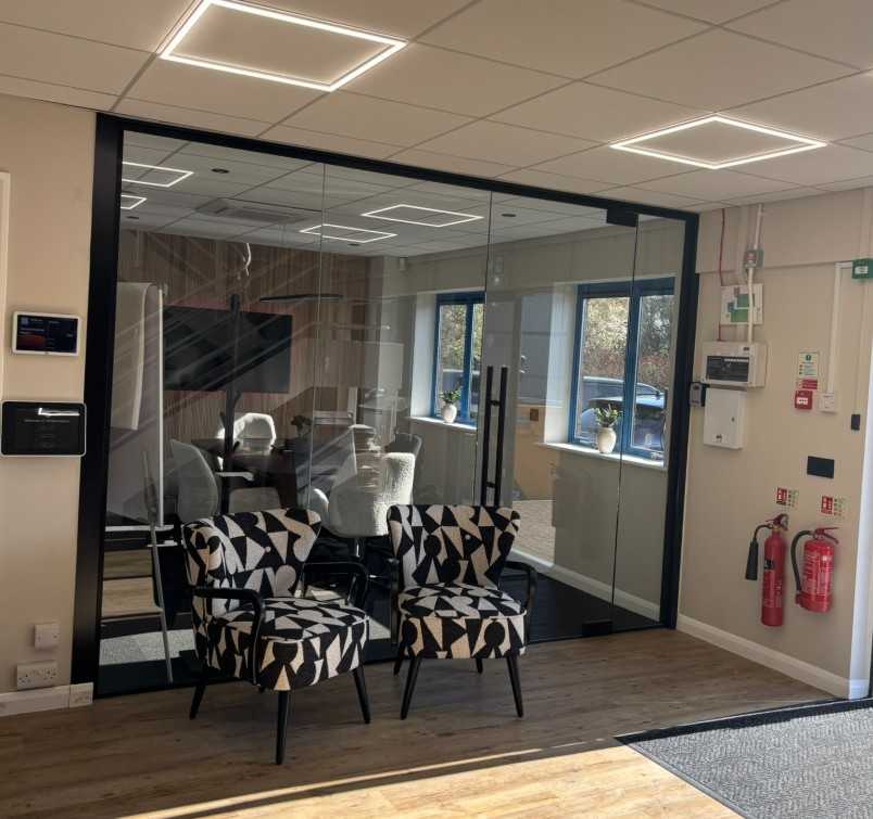 Double-glazed aluminium-framed glass meeting room partition with integrated door and acoustic seals