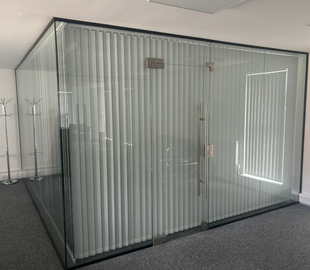 Aluminium-framed glass office partition with meeting room door and manifestation banding