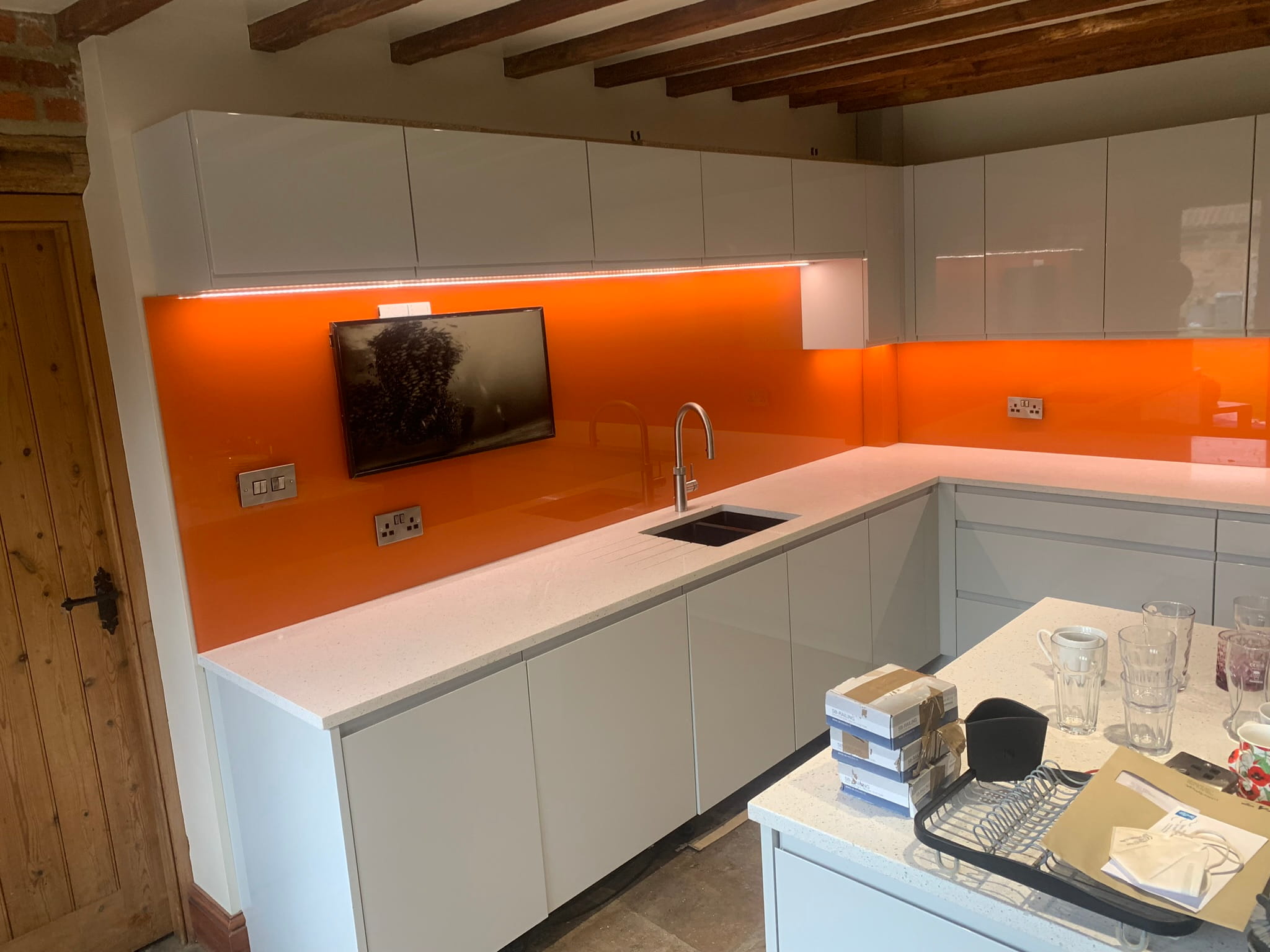 Toughened glass kitchen splashback installed behind hob — seamless and grout-free