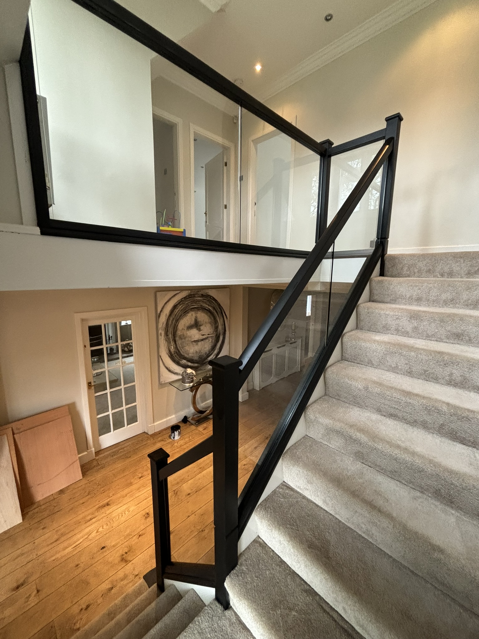 Black timber staircase with glass balustrade panels