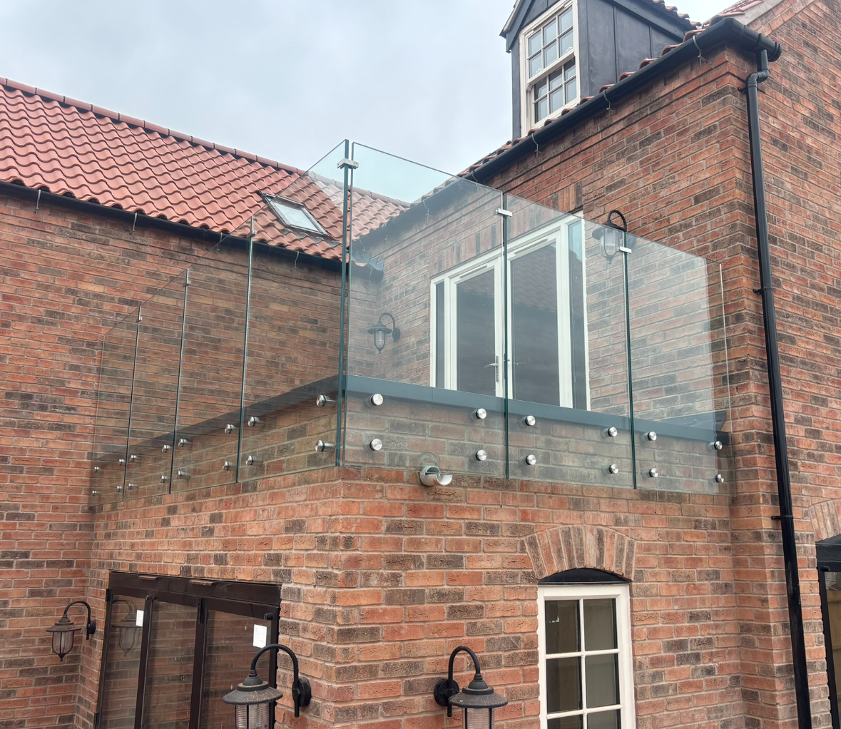 Stainless steel standoff buttons and spacer fixings for face-mounted glass balustrade