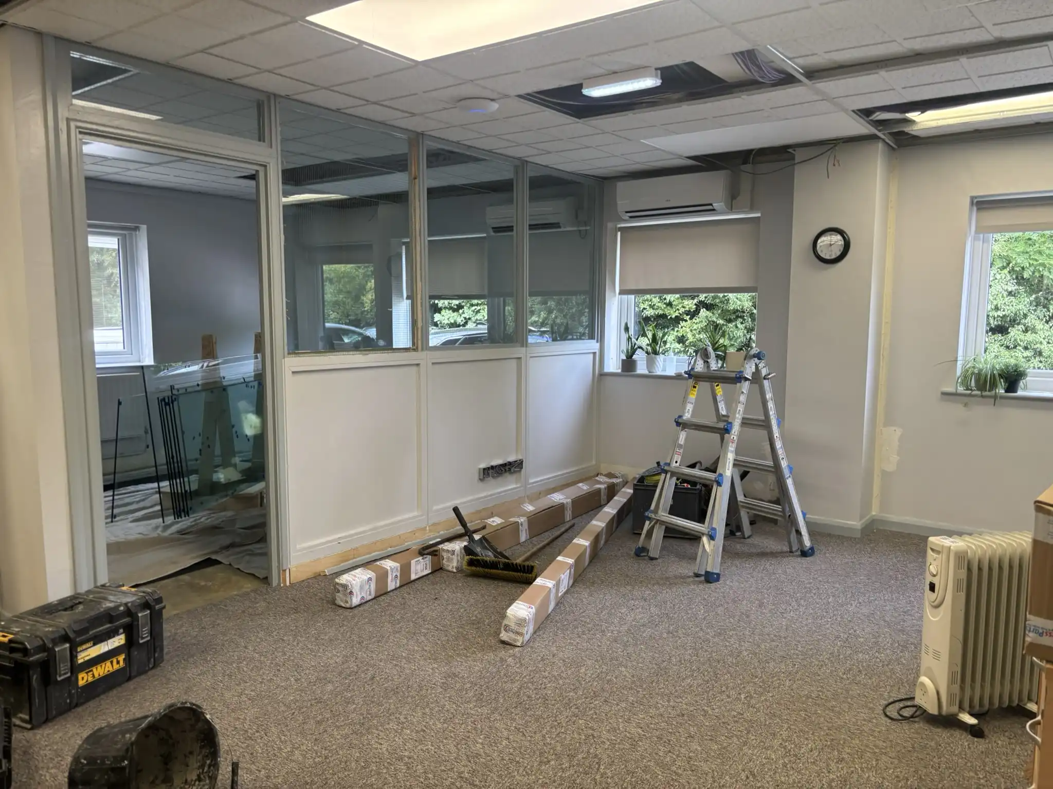Black framed glass office partition system with full-height glazed door and privacy frosting