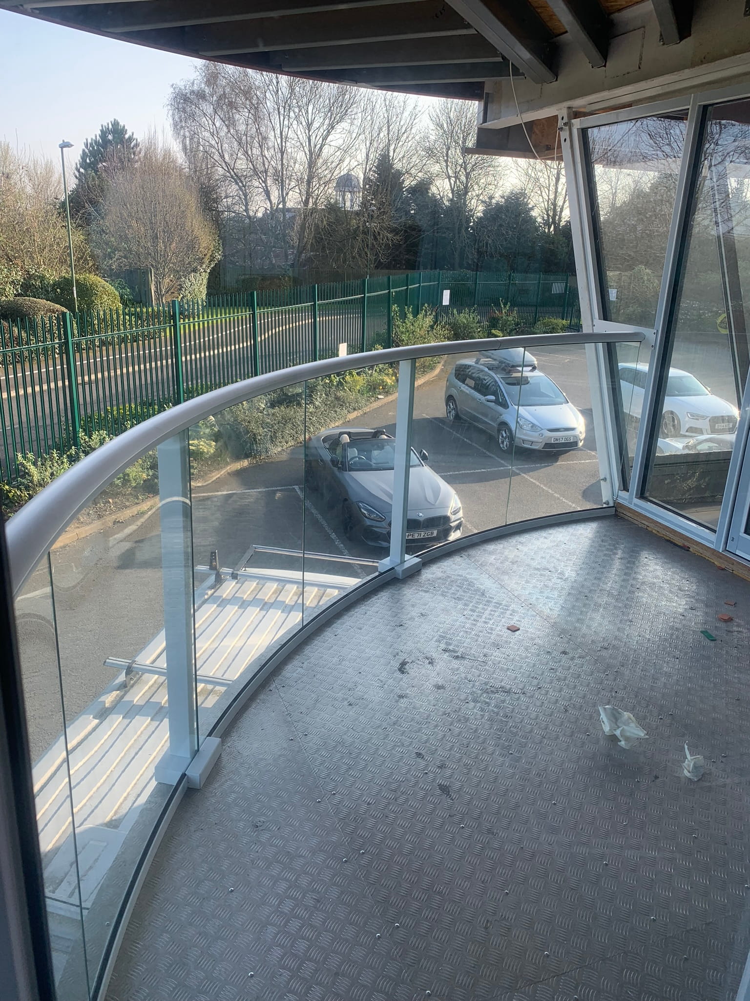 Detail of curved Balconnette Aerofoil balustrade with bent glass panels at Lotus showroom