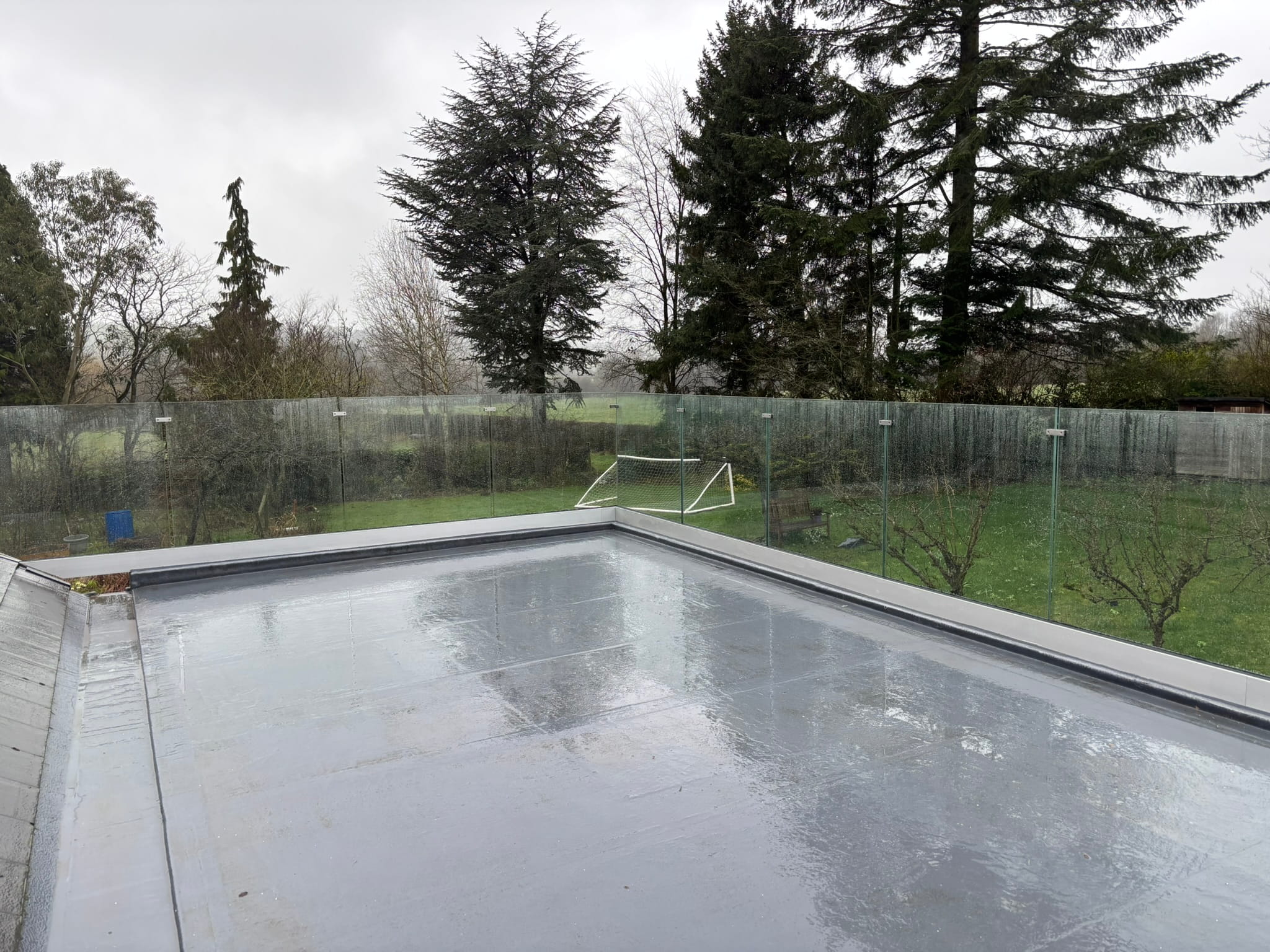 Overview of frameless glass balustrade running around flat roof deck perimeter in Doncaster