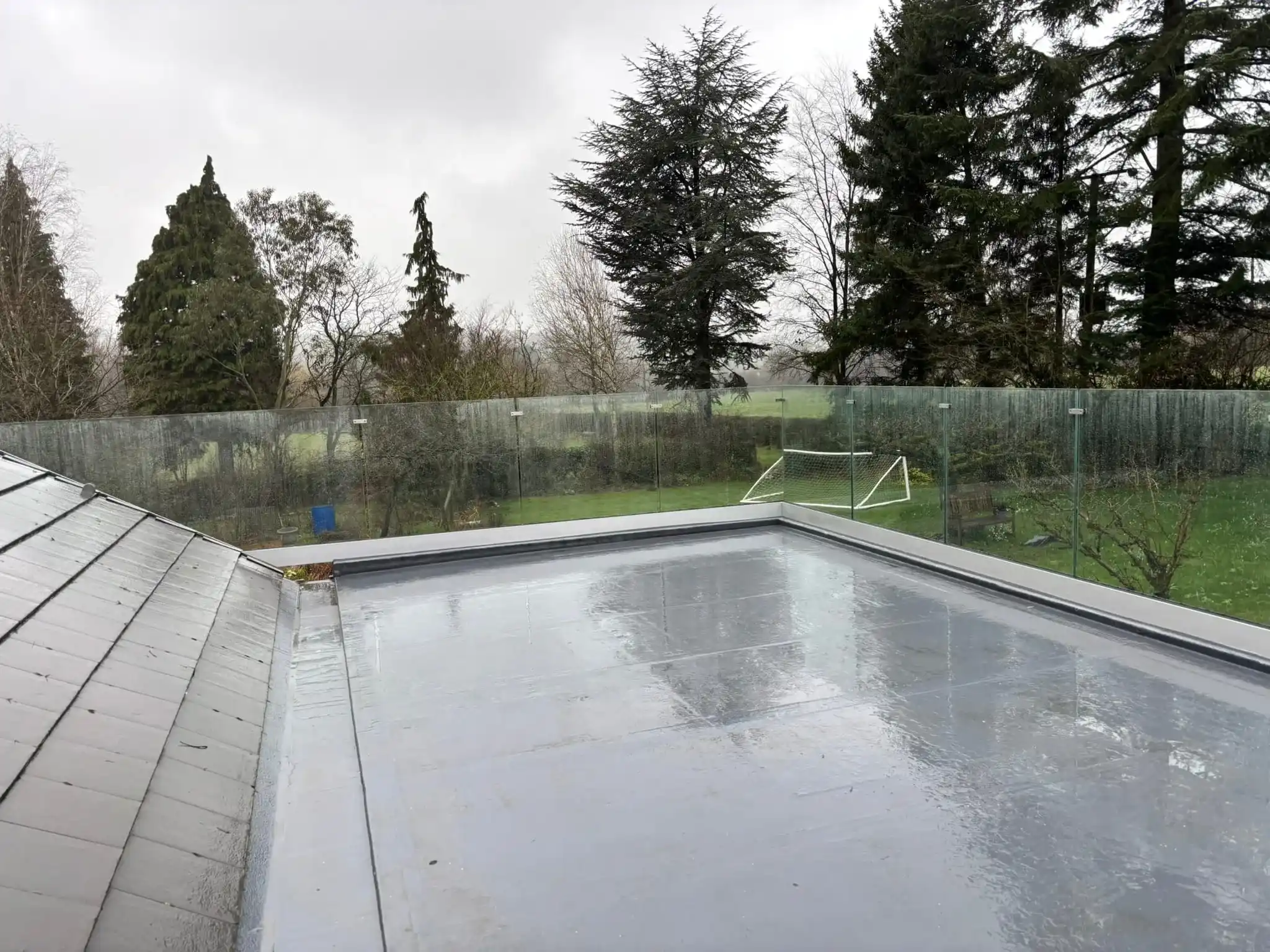 View from balcony through frameless glass balustrade panels over large garden in Doncaster