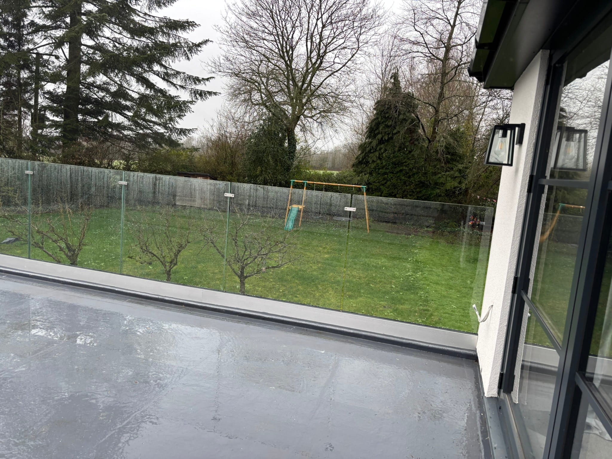 Frameless glass balustrade viewed from bifold door opening onto Doncaster flat roof balcony
