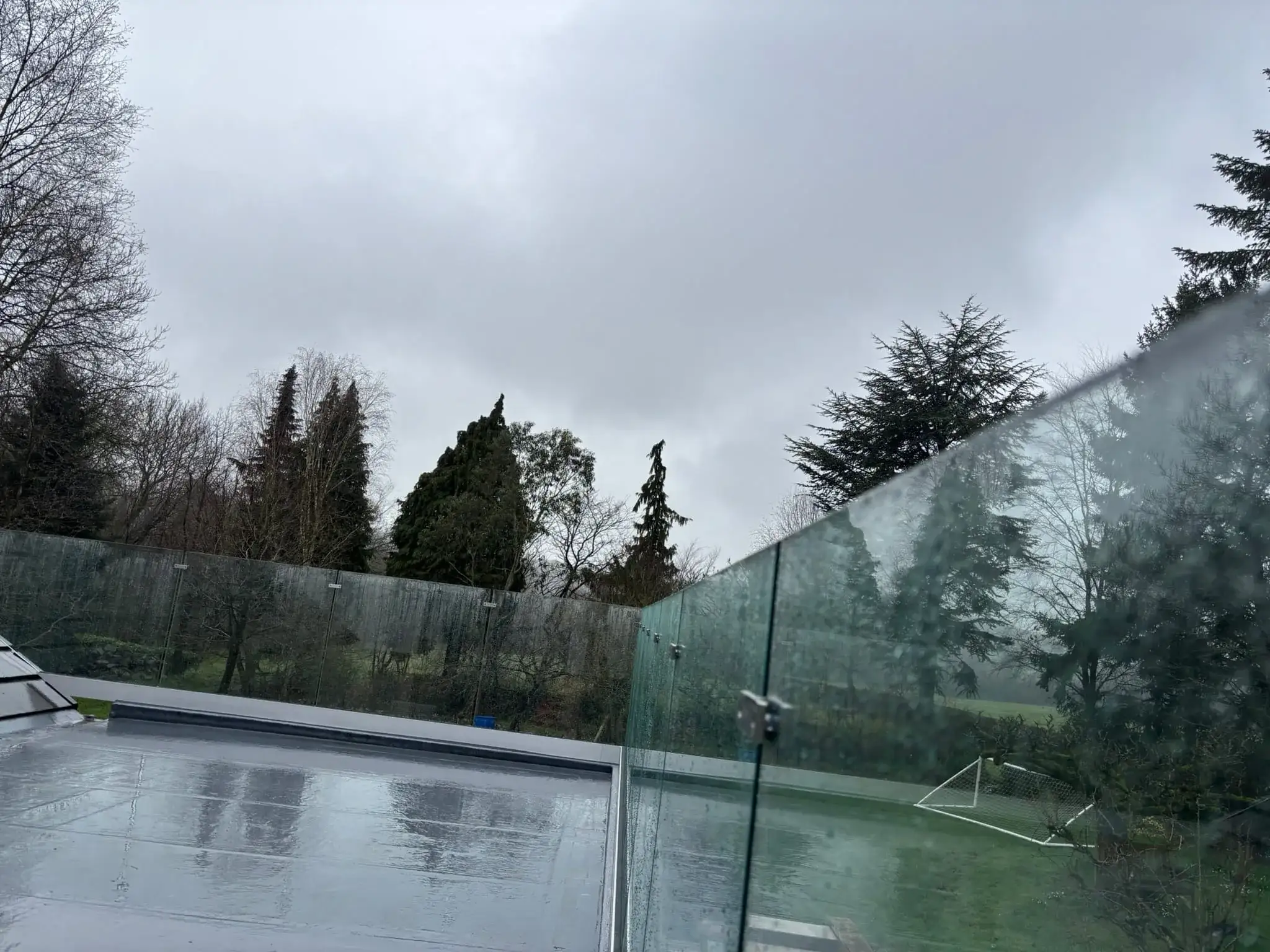 Overview of frameless glass balustrade running around flat roof deck perimeter in Doncaster