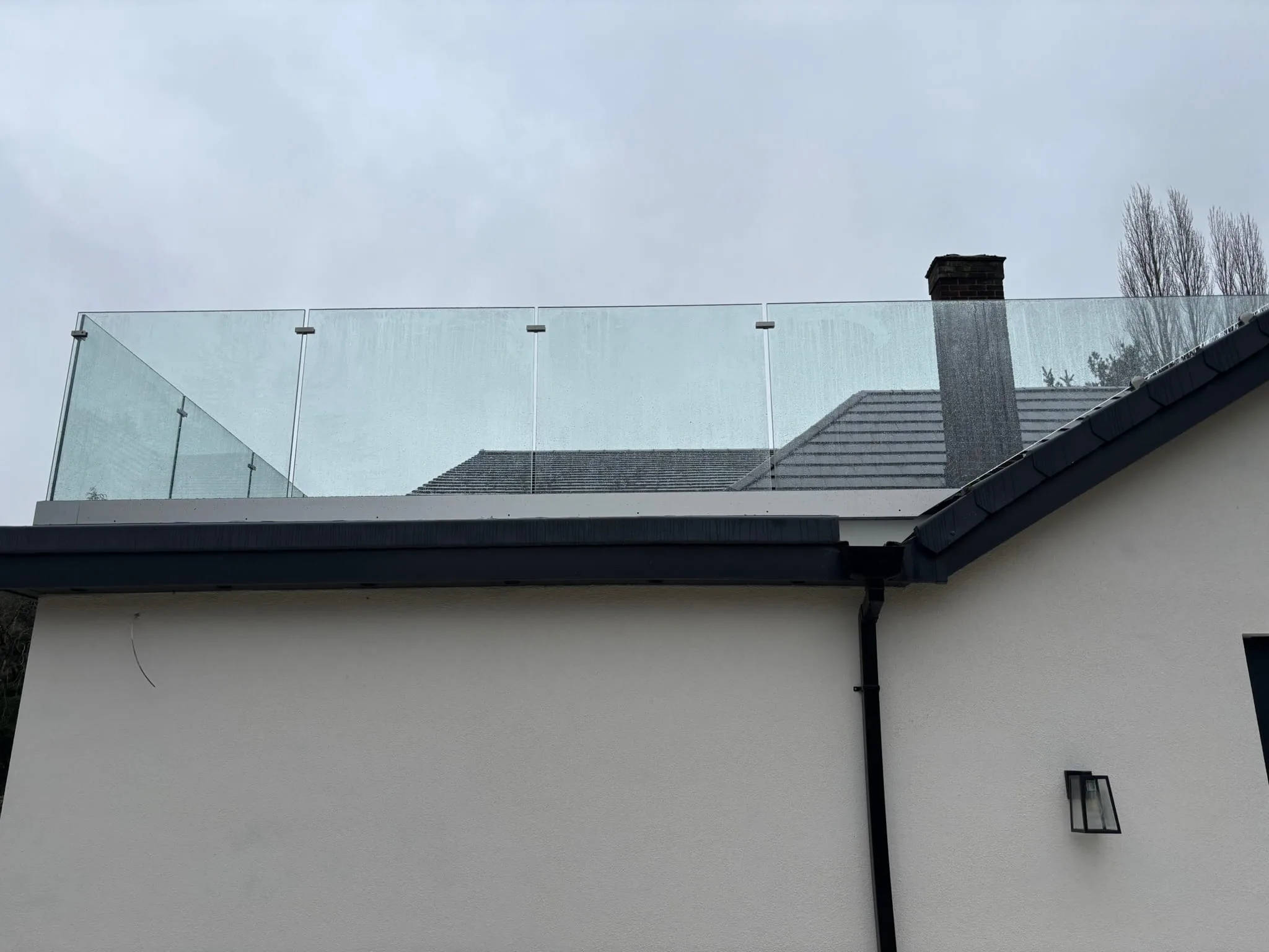 Aerial view over slate roof showing frameless glass balustrade line on Doncaster property