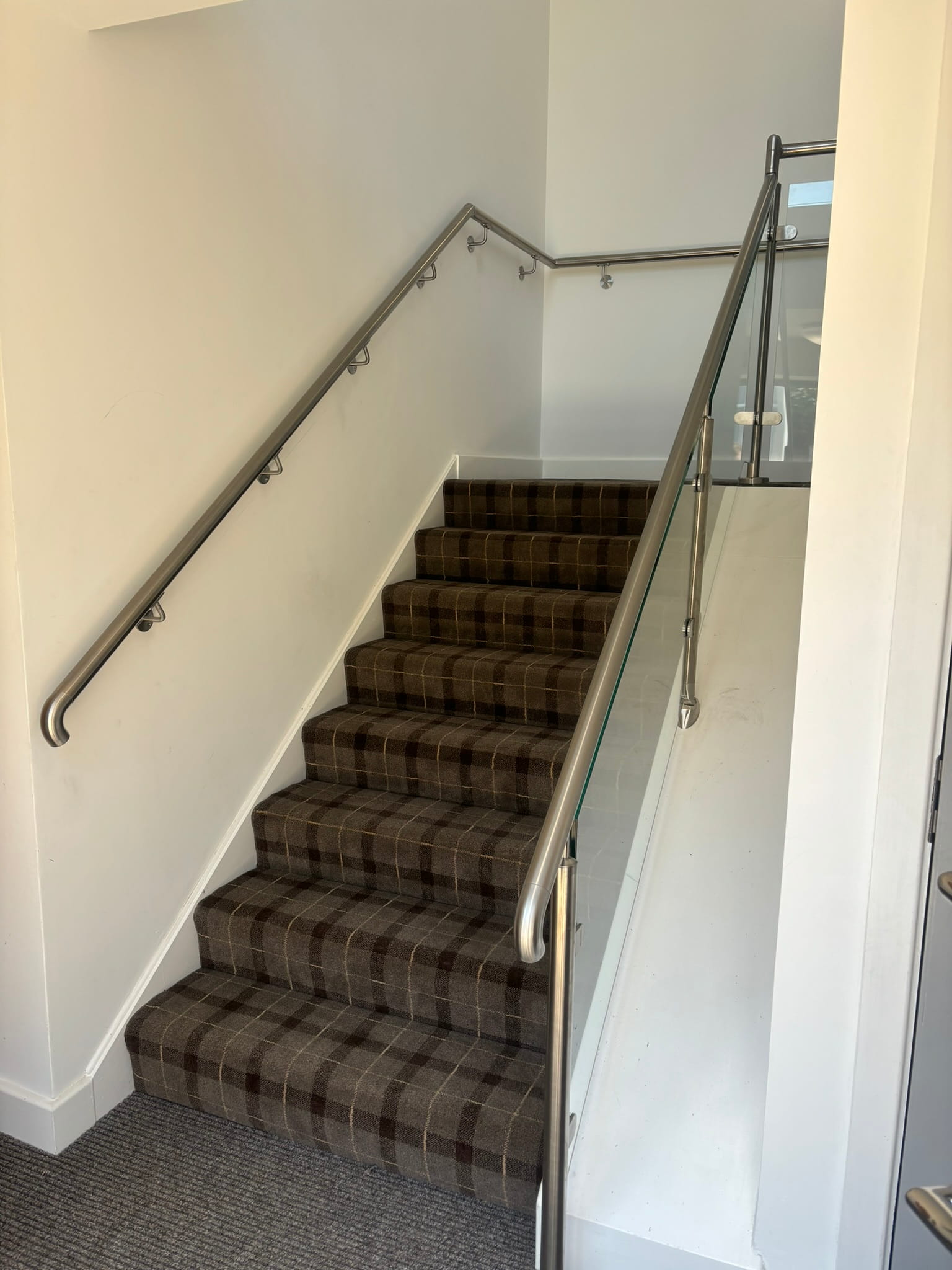 Stainless steel post and glass panel balustrade on HMO staircase in Rotherham with wall-mounted handrail opposite