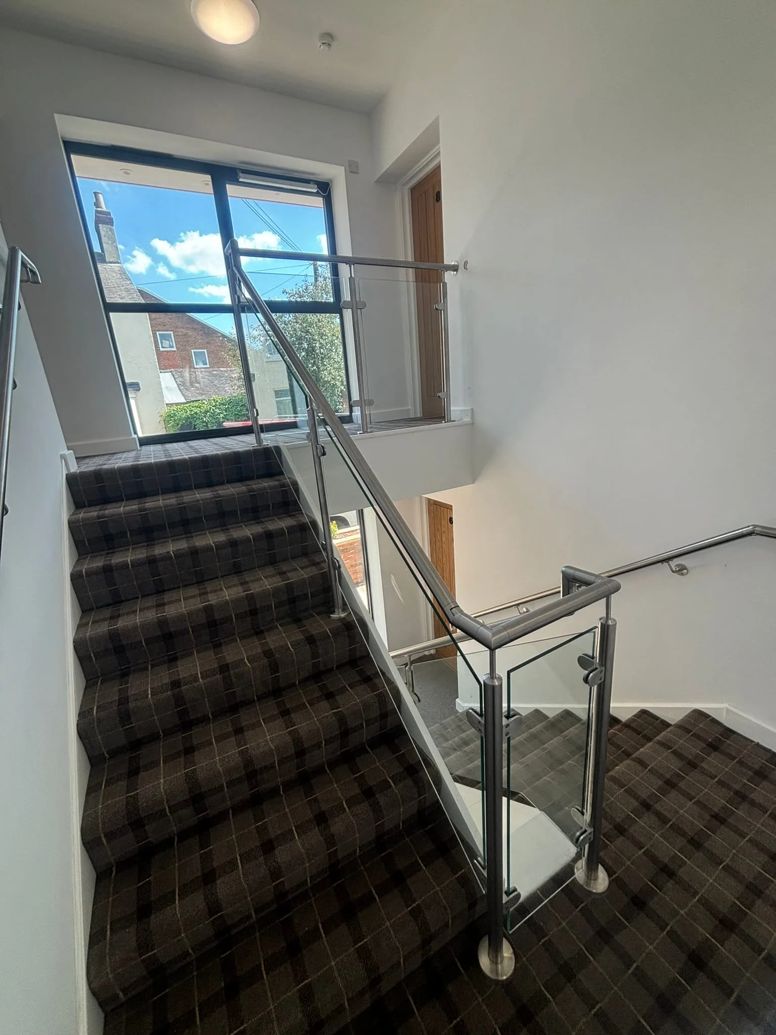 Upper landing stainless steel post and glass panel balustrade at HMO staircase head, Rotherham