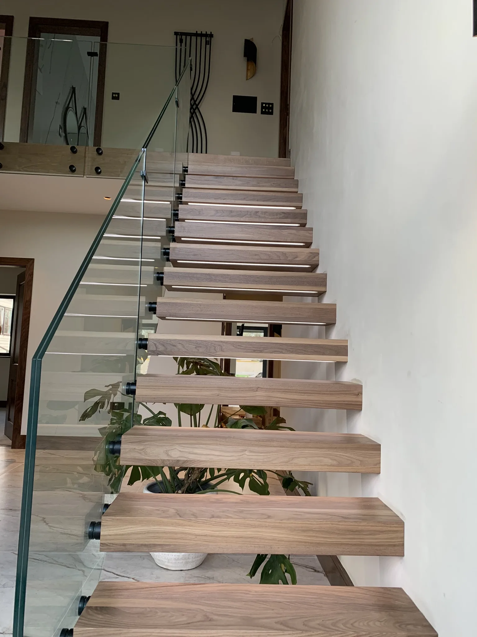Floating stair treads with internal steel structure and glass railing