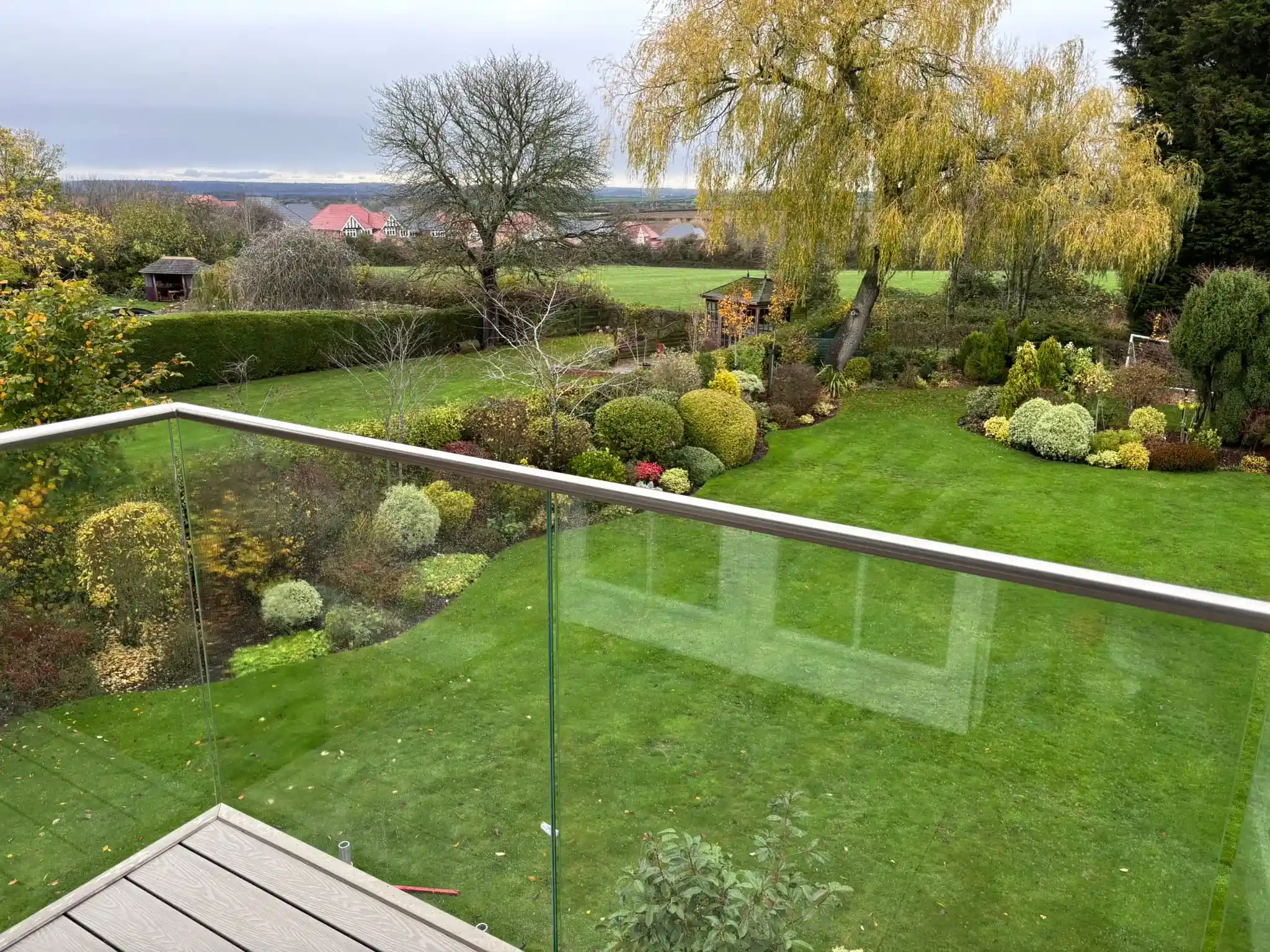 Interior view through bifold doors to garden with frameless Juliet balcony, Chesterfield.