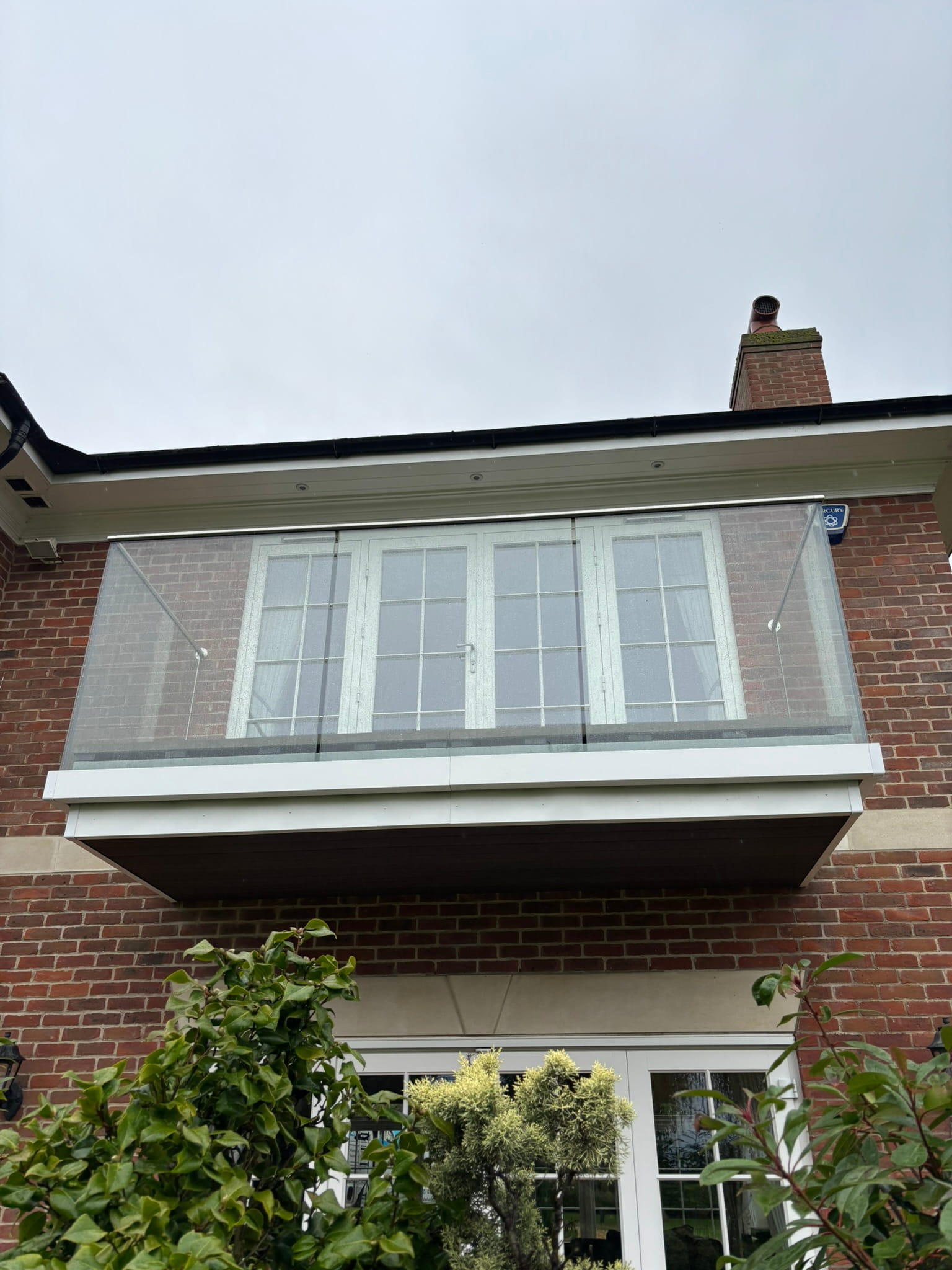 Completed frameless glass balustrade with aluminium fascia board, balcony renovation Nottingham
