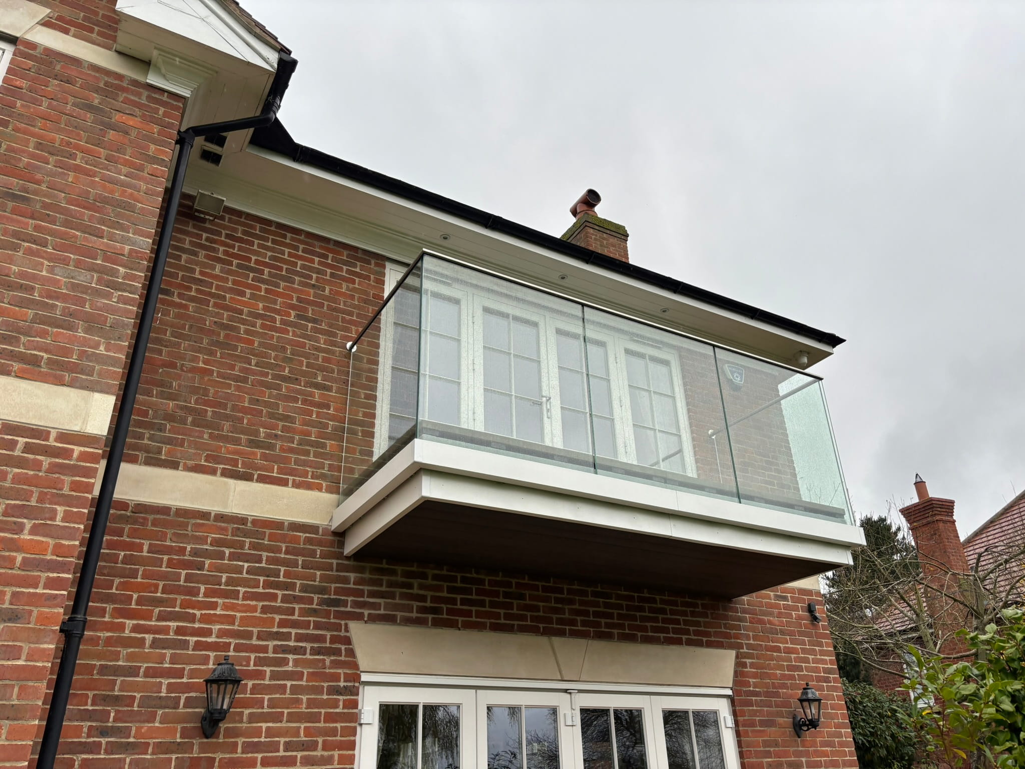 Frameless glass balcony renovation — new channel system and composite decking, Nottingham