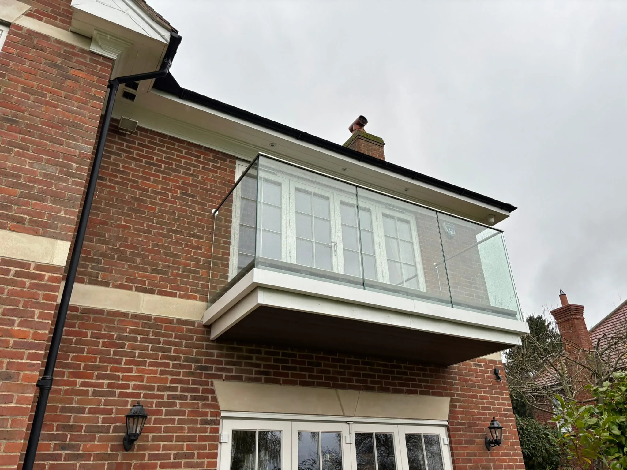 Frameless glass balustrade with stainless handrail on cantilevered balcony, Nottingham.