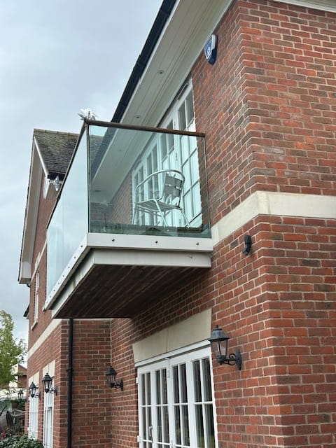 Side view of renovated frameless glass balustrade and composite decking, Nottingham