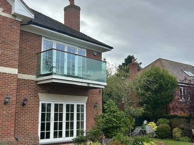 Glass balustrade with stainless steel handrail on first floor balcony.