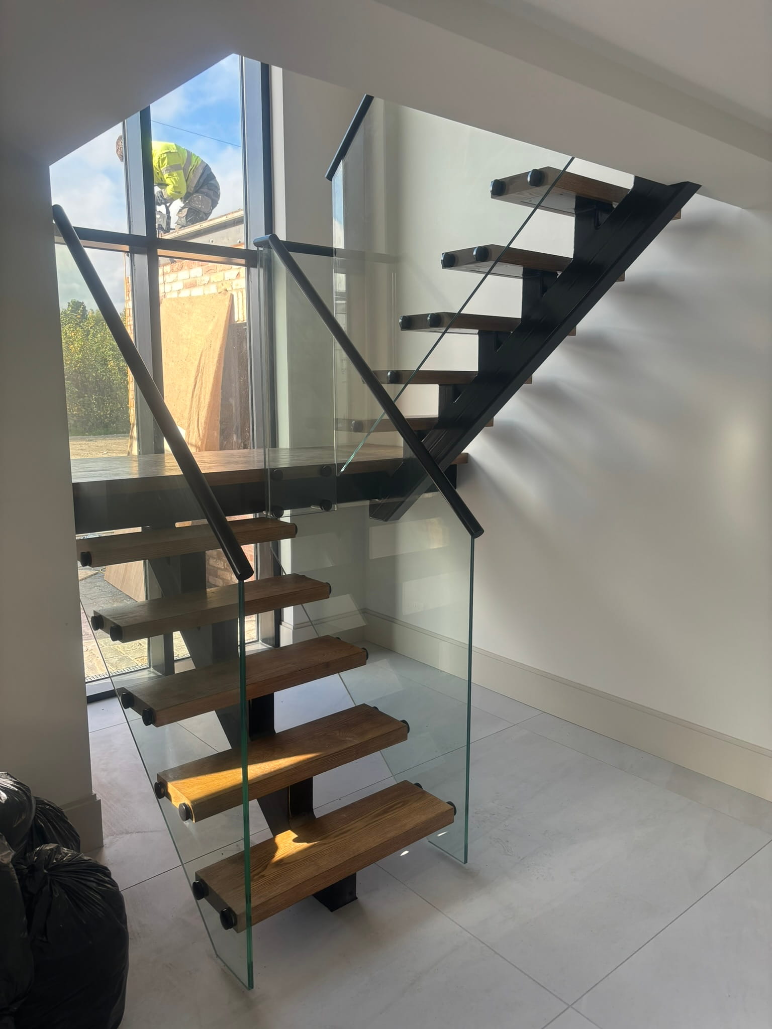 Frameless glass staircase balustrade with standoff buttons and black handrail, Lincoln