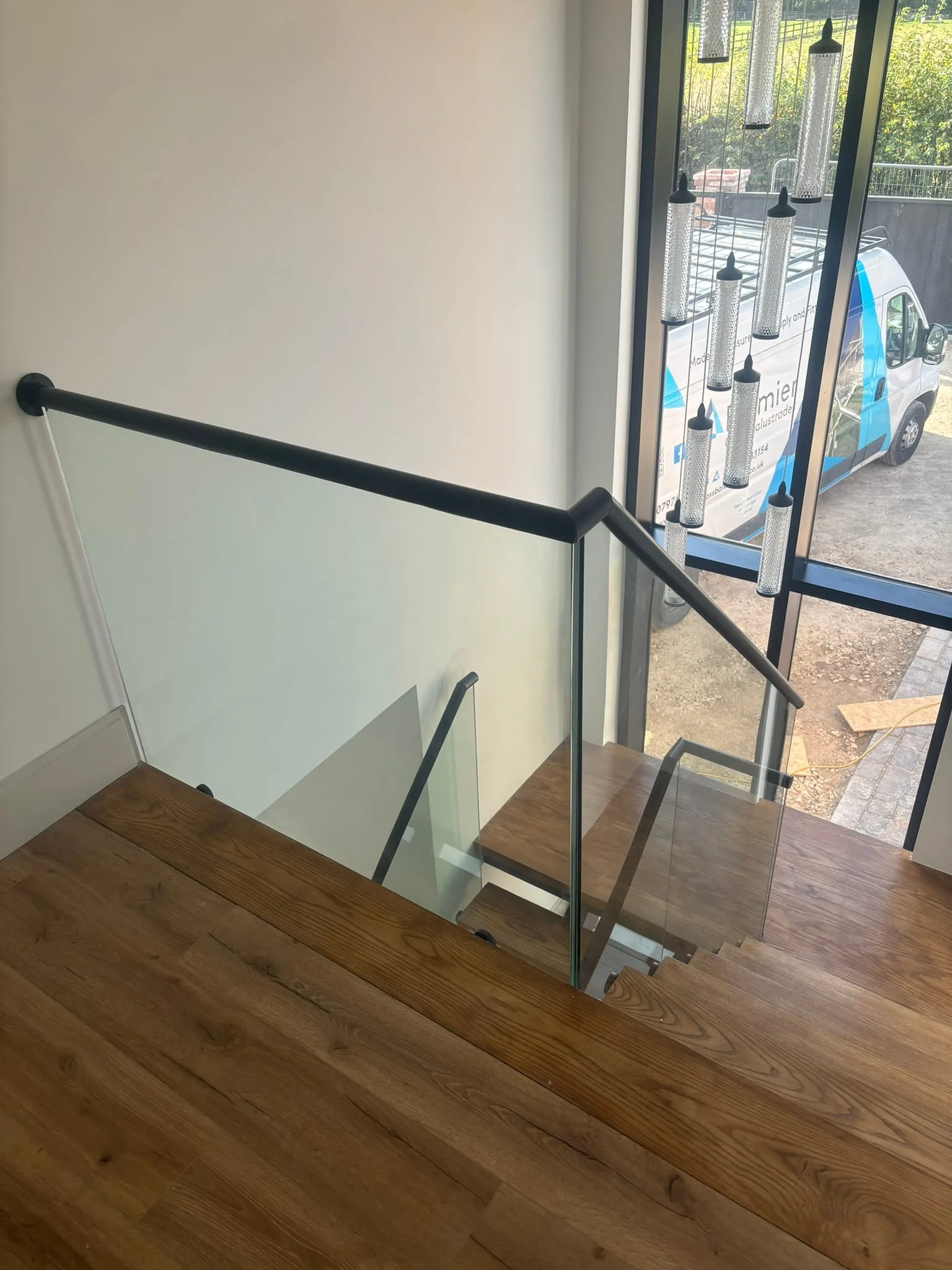 Black handrail fitted to frameless glass staircase system