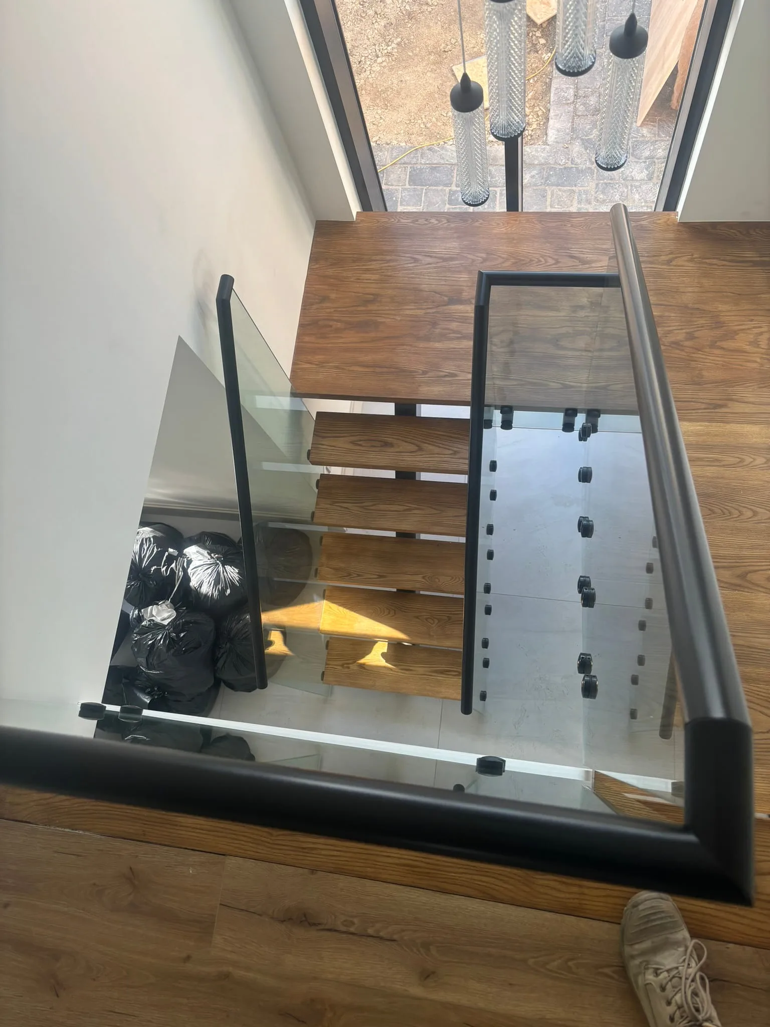 Glass balustrade aligned along angled staircase string