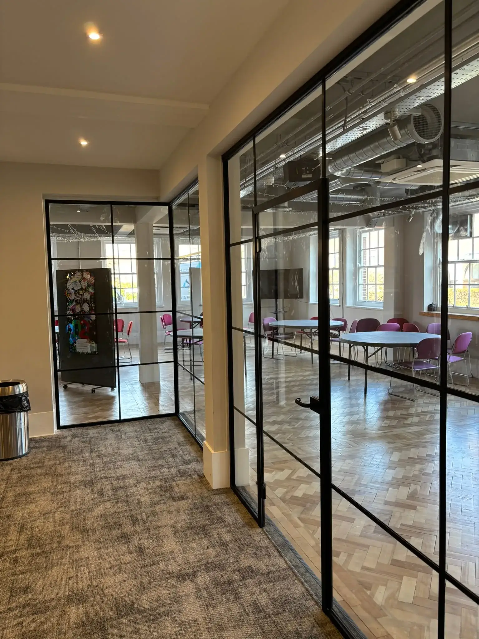 Industrial style glass partition with crittall bars adhered to glass