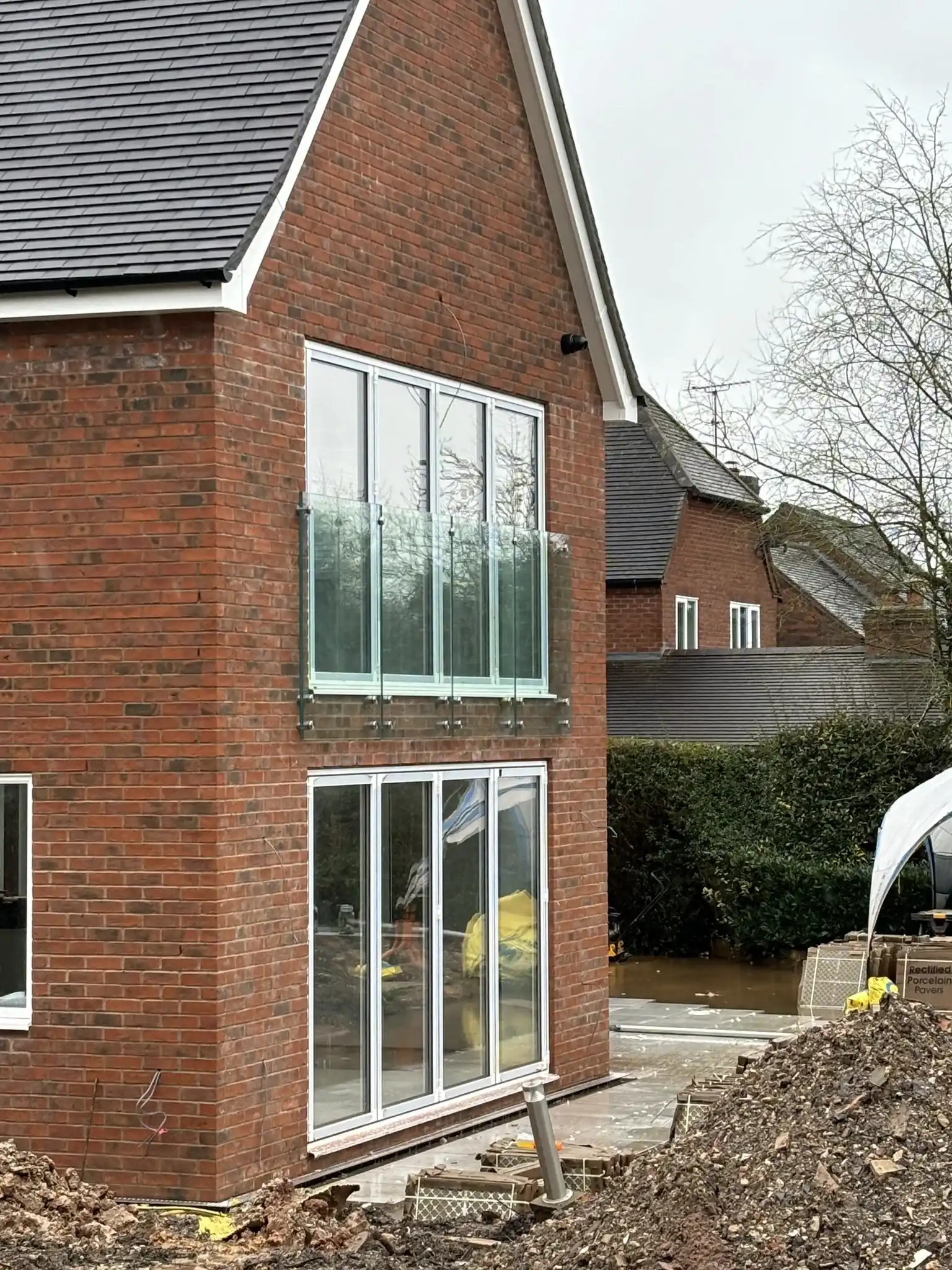 Side view of frameless glass Juliet balcony panels on a new-build near Chesterfield.
