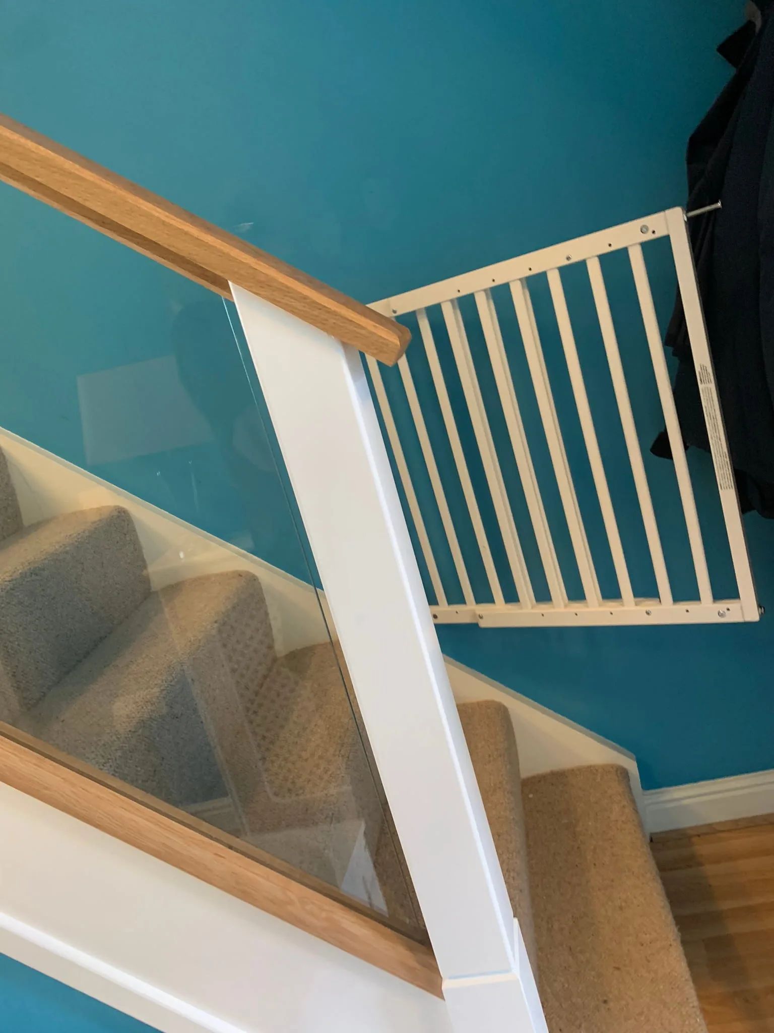 Looking up renovated glass staircase with clear panels and white square newel posts, Derby