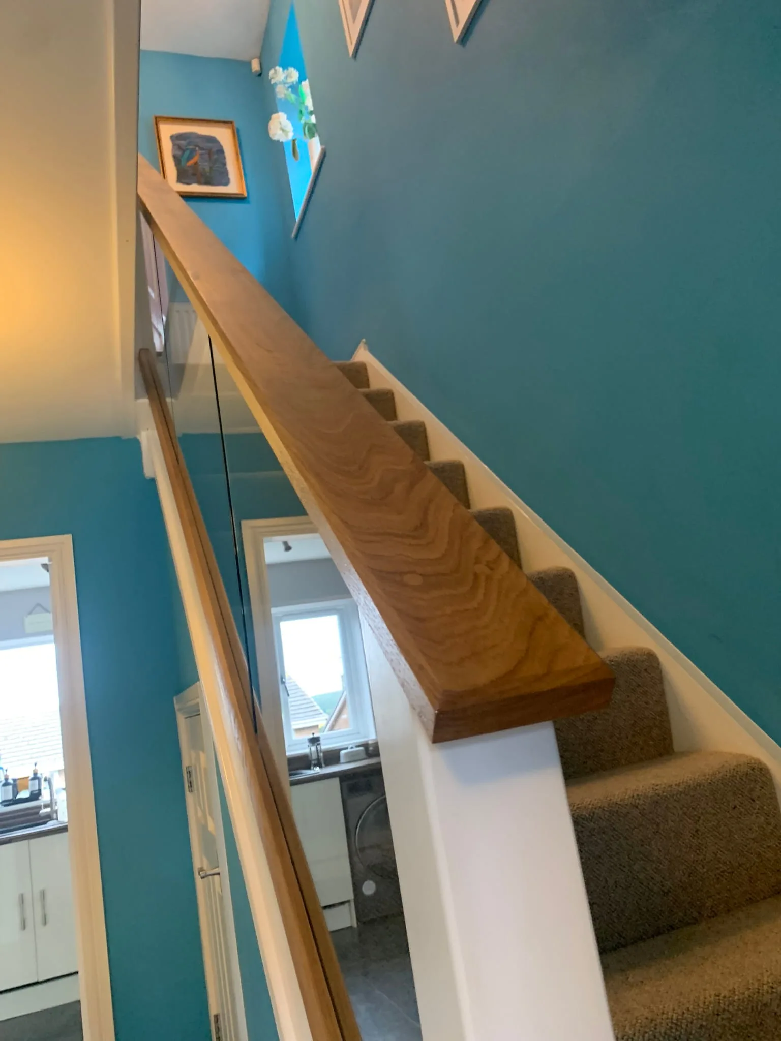 Close-up of hand-planed oak handrail grain on glass staircase renovation, Derby