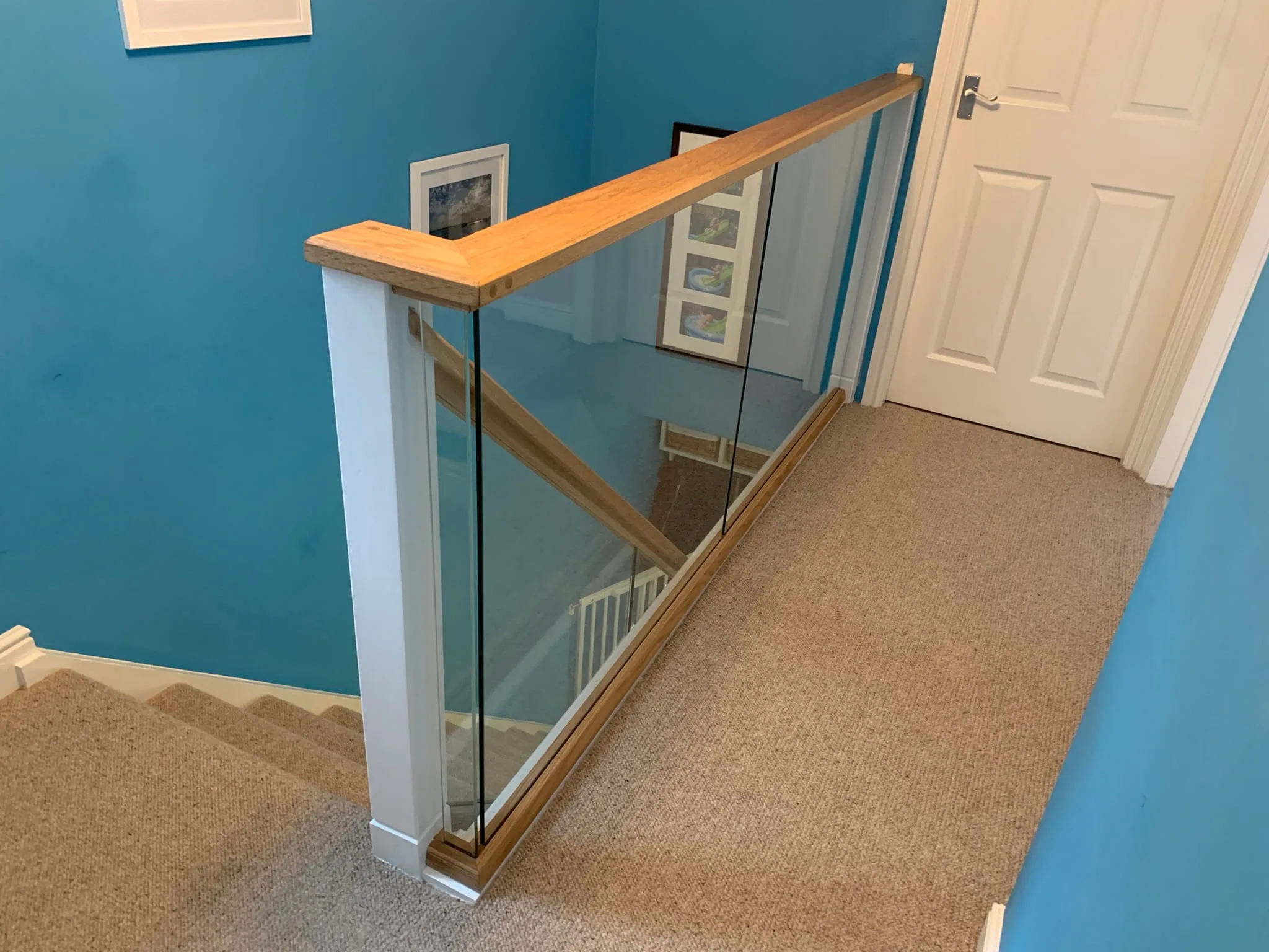 Toughened glass panels set in grooved oak rails with no visible fixings, Derby staircase renovation.