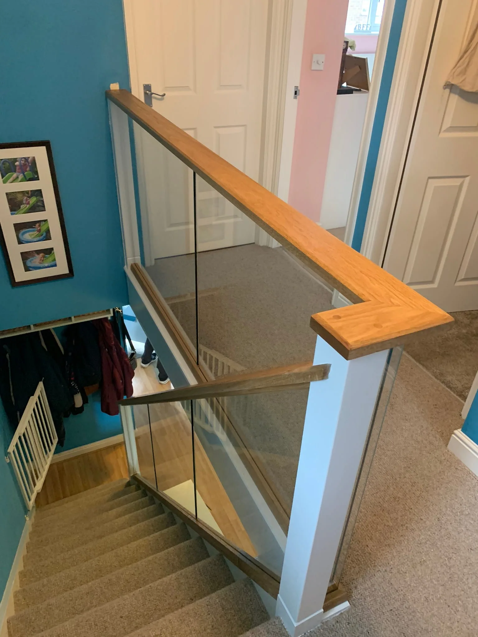 Glass staircase renovation with white posts and oak handrail, Derby, hallway view.