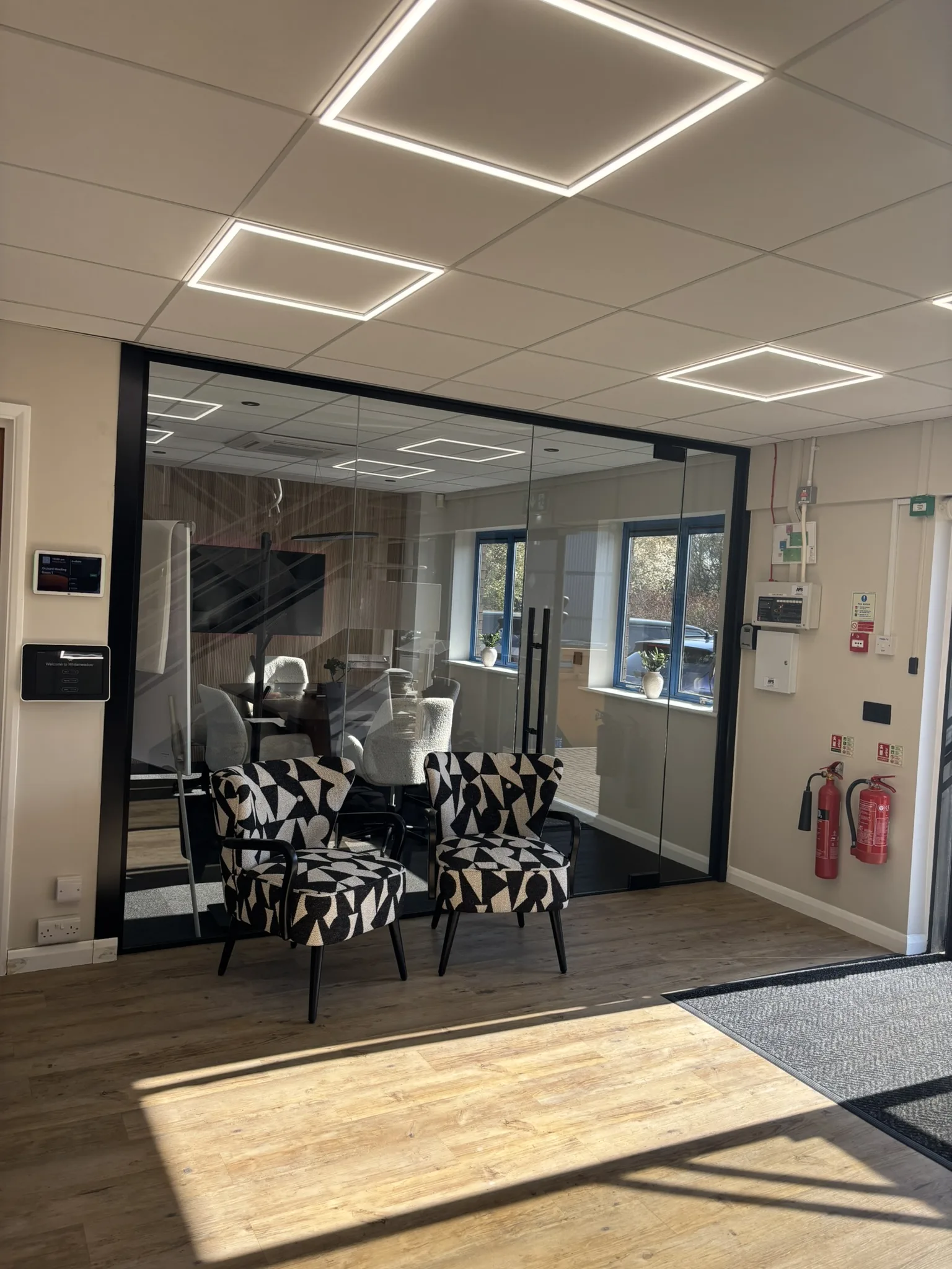 Glass office partition with black wall trimming and aluminium frame finish