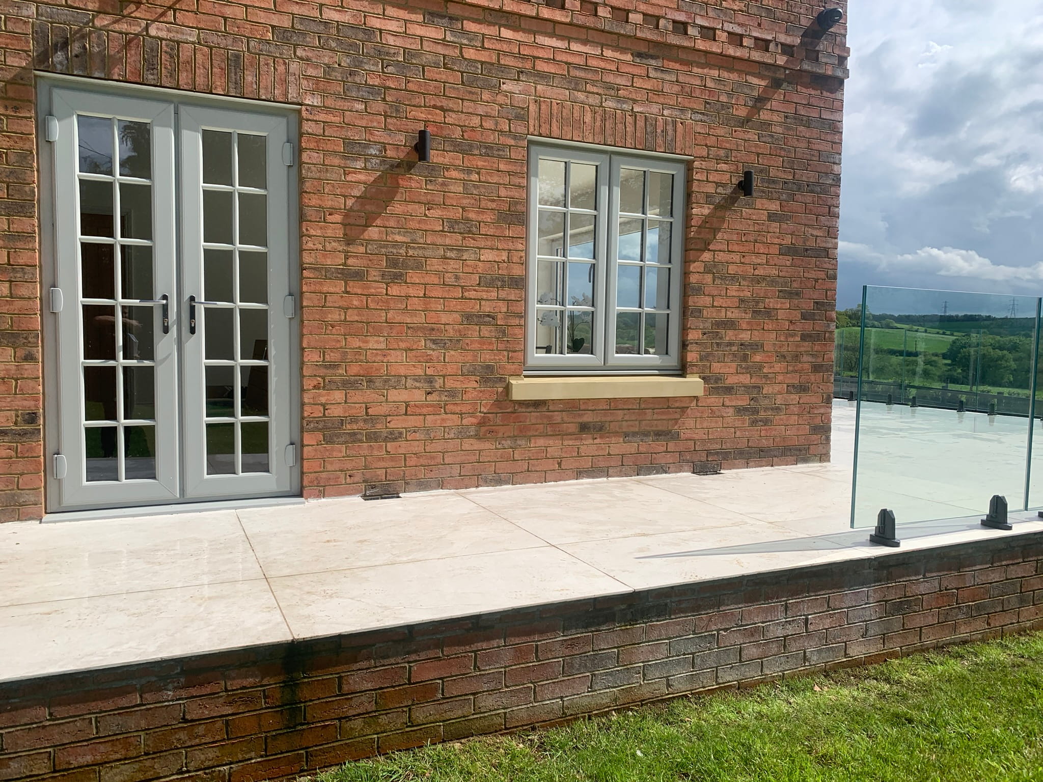 Glass balustrade corner detail with stainless spigot fixings on porcelain tiles, Worksop
