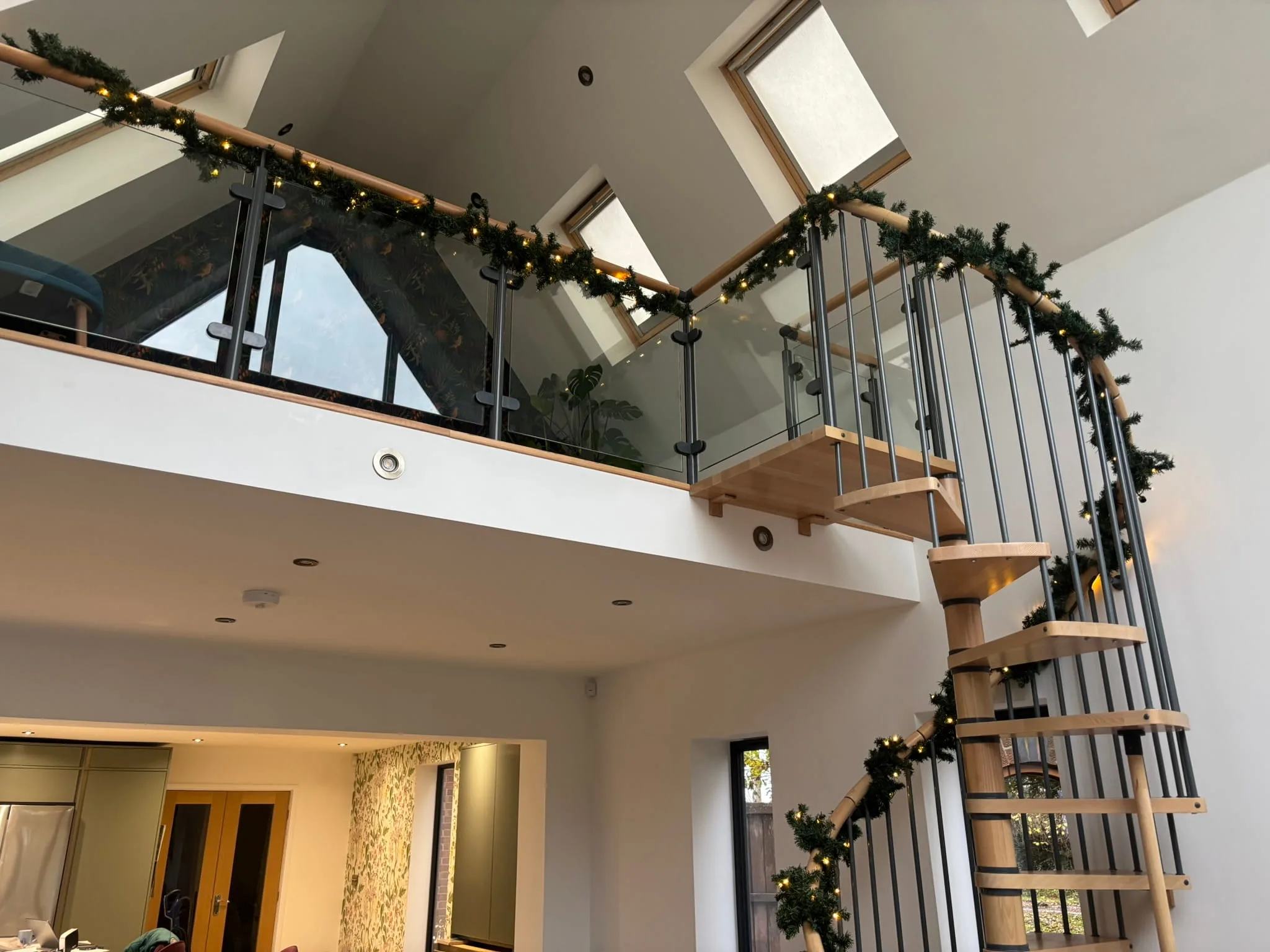 Spiral staircase beech tread detail with steel spindles and glass balustrade, Bingham