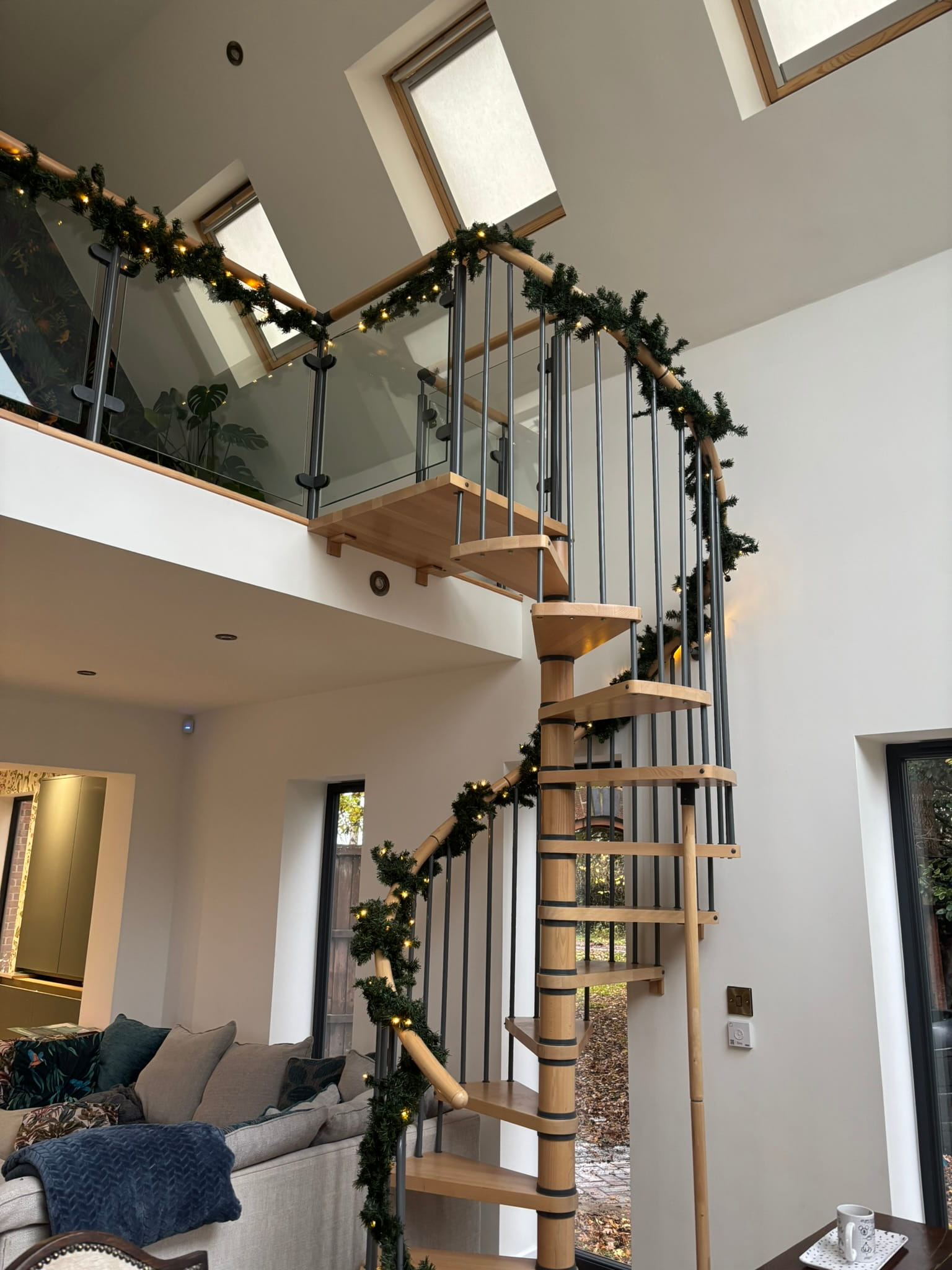 Spiral staircase beech tread detail with steel spindles and glass balustrade, Bingham