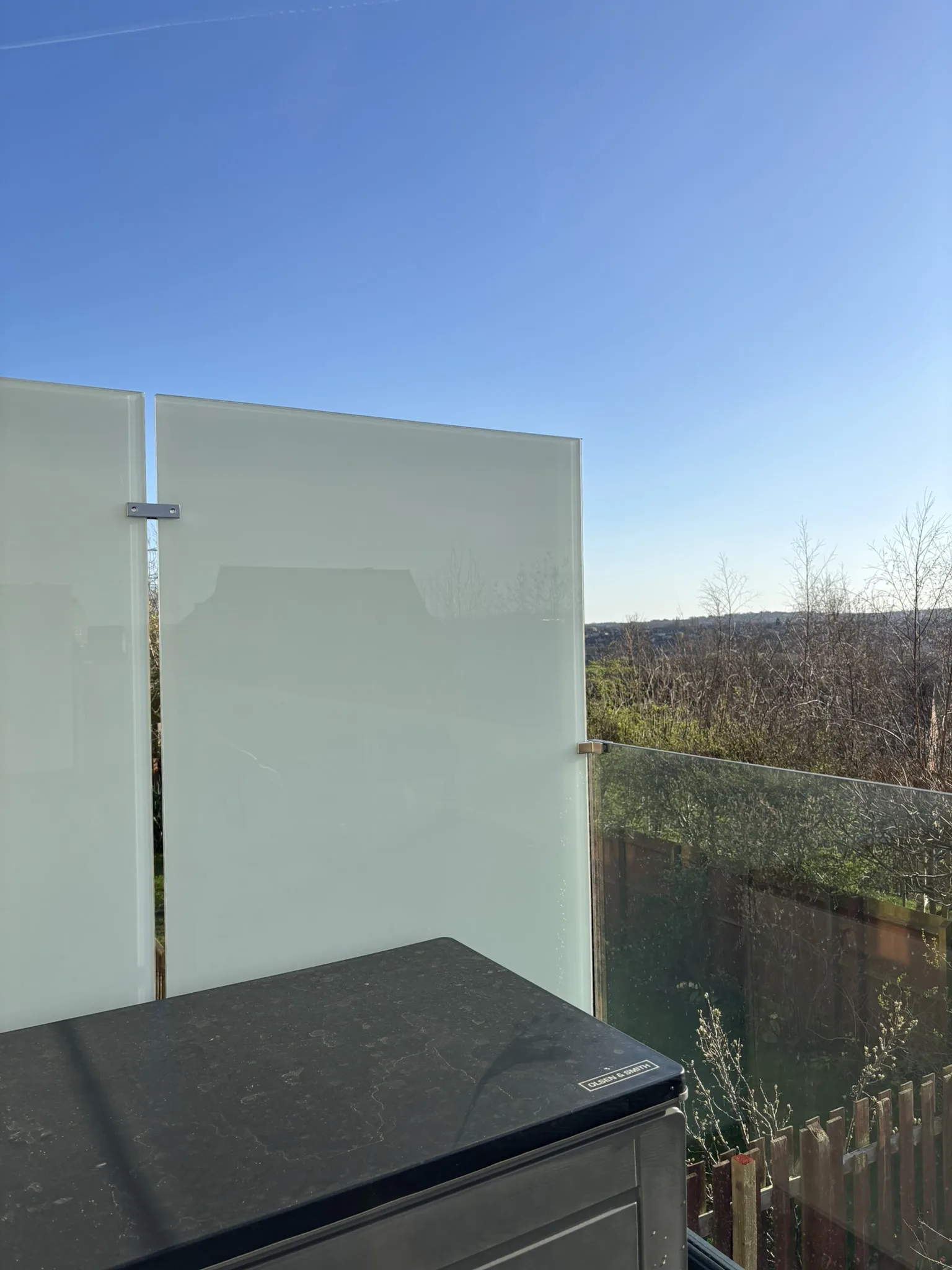 Frosted glass privacy screen installed on balcony seating area