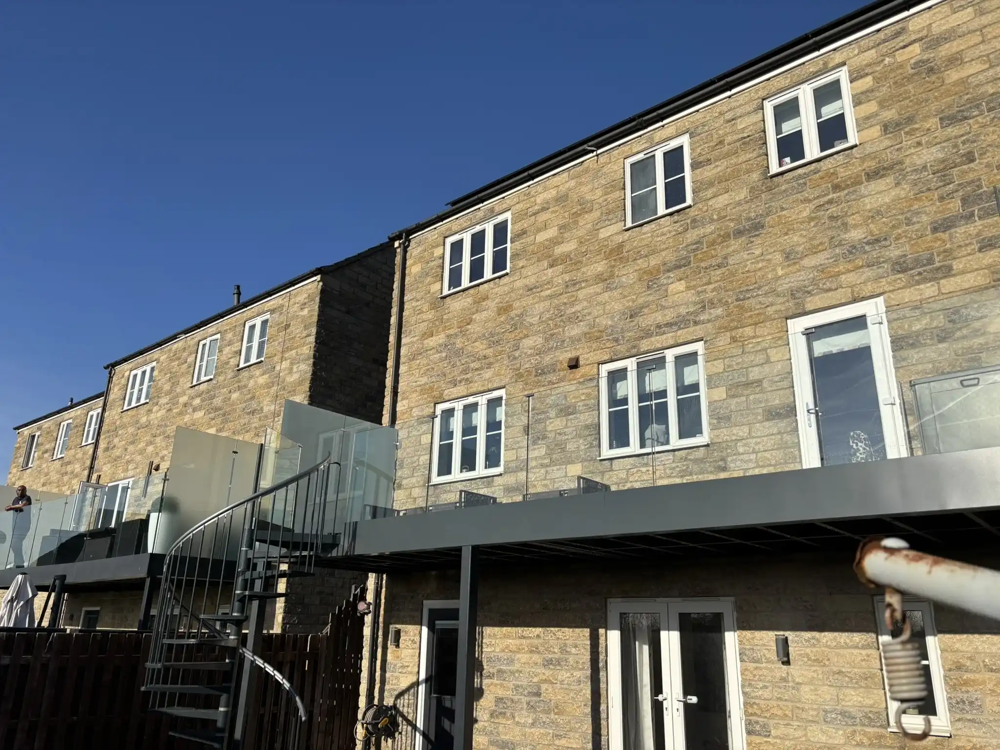 Side view of balcony showing glass balustrade and privacy screen