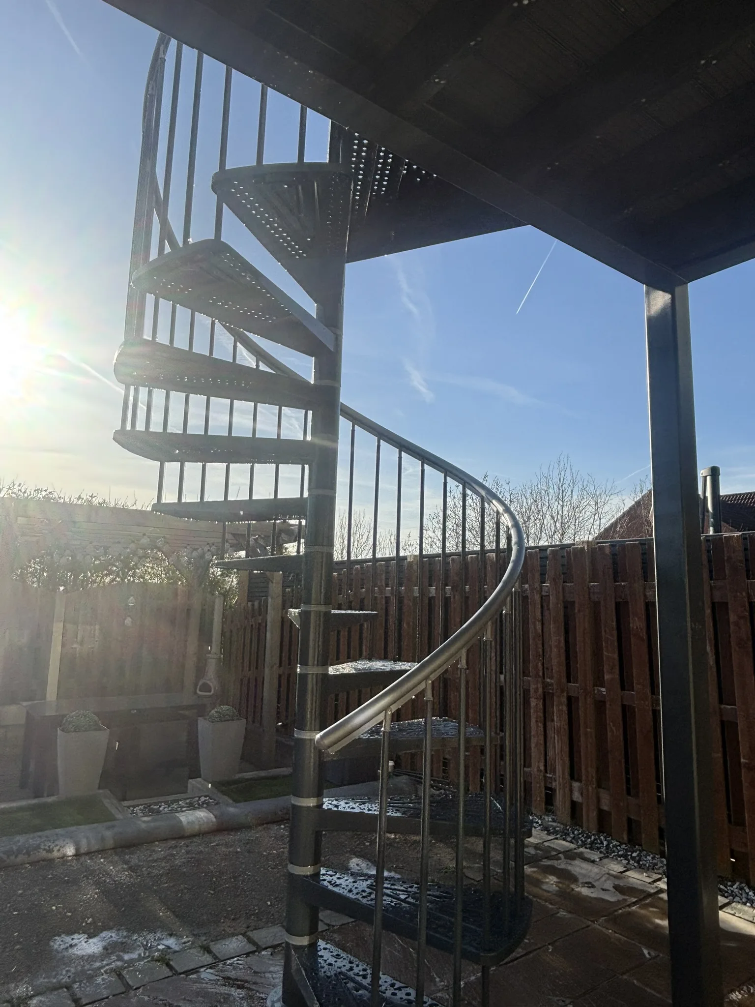 Modern outdoor living space with elevated glass balcony